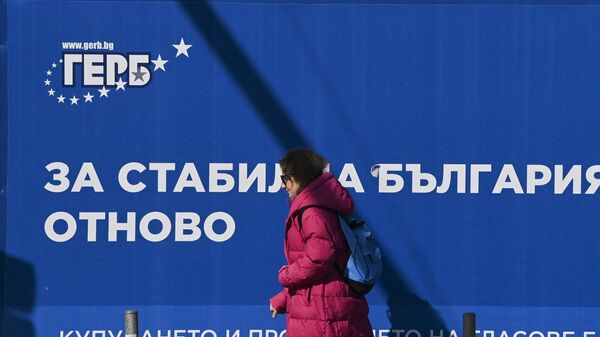 Женщина проходит мимо плаката партии ГЕРБ в Софии