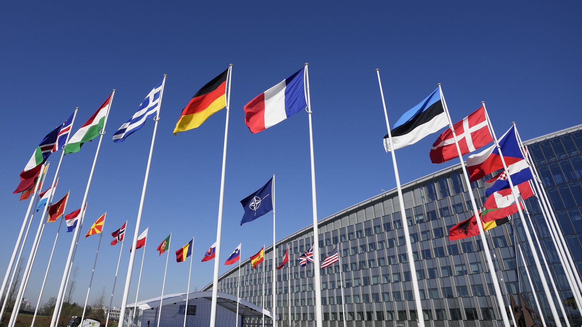 Пустой флагшток между флагами Франции и Эстонии у здания штаб-квартиры НАТО в Брюсселе - РИА Новости, 1920, 13.04.2023