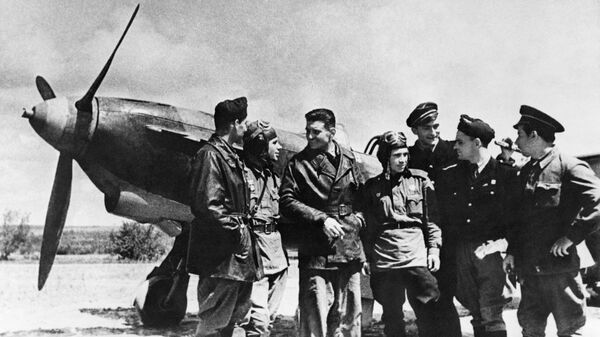 Советские и французские летчики эскадрильи Нормандия-Неман беседуют, стоя рядом с самолетом в районе Курской дуги