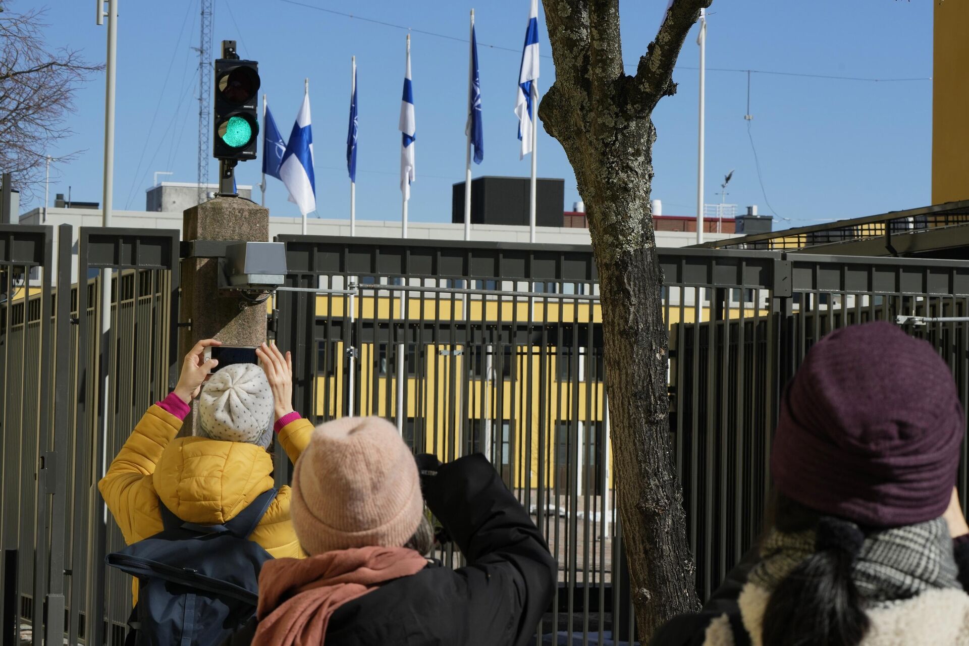 Люди фотографируют флаги НАТО и Финляндии над зданием Министерства иностранных дел в Хельсинки Люди фотографируют флаги НАТО и Финляндии над зданием Министерства иностранных дел в Хельсинки - РИА Новости, 1920, 22.12.2025