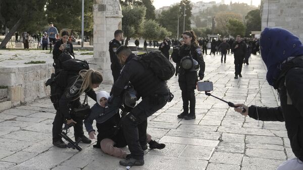Израильская полиция задерживает палестинскую женщину на территории мечети Аль-Акса в Иерусалиме