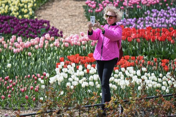 Посетительница фотографируется на открытии ежегодной выставки Парад тюльпанов в Никитском ботаническом саду в Крыму