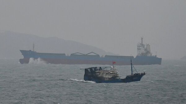 Грузовое судно проплывает мимо острова Пингтан (ближайшая к Тайваню точка) в провинции Фуцзянь в Китае. 6 апреля 2023