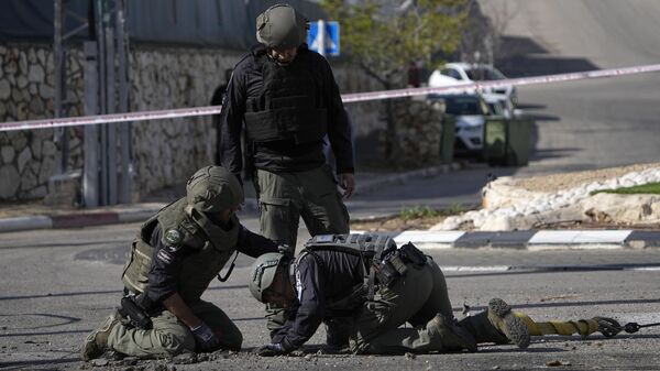 Израильские полицейские на месте падения перехваченной ракеты, выпущенной с территории Ливана, в Шломи