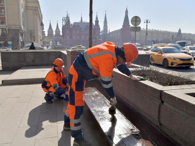 Сотрудники коммунальной службы красят лавочки на Тверской улице в Москве