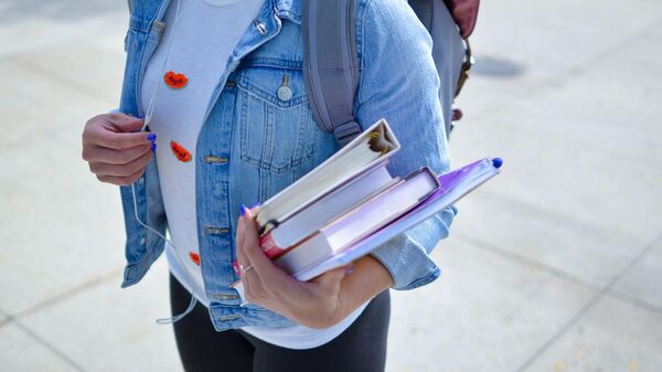 Студентка с учебниками в руке