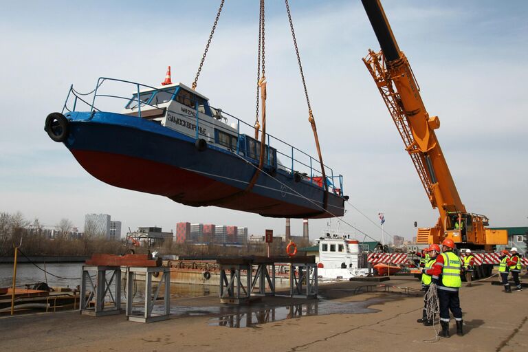 Сотрудники ГУП Мосводосток спускают грузовой катер Яуза-1 во время подготовки к открытию технической навигации на Москву-реку