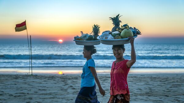 Женщины продают фрукты на пляже Нгапали, Мьянма
