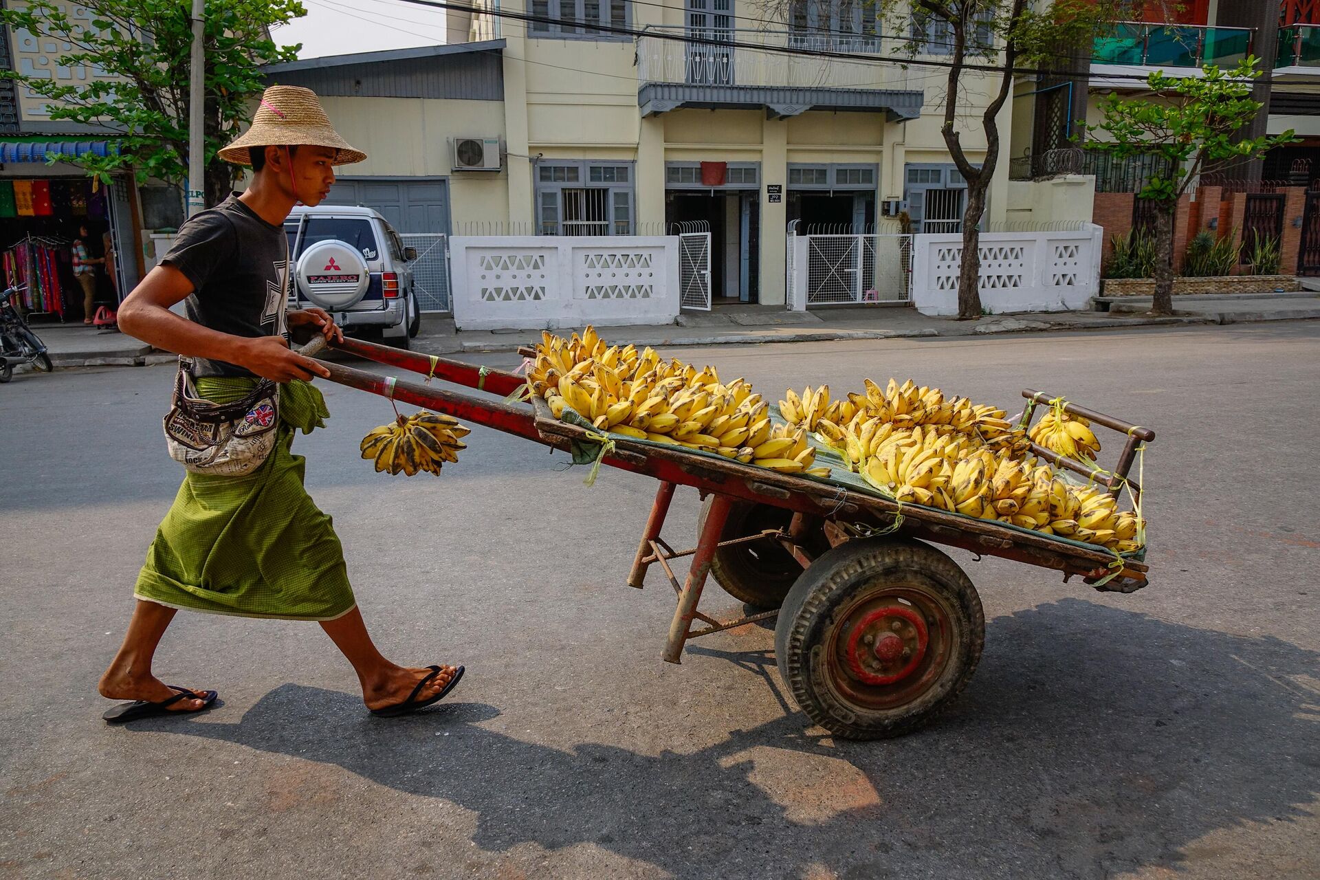 Мужчина в традиционной одежде продает бананы на улице Янгона, Мьянма - РИА Новости, 1920, 09.06.2023