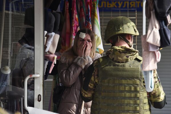 Военнослужащий опрашивает женщину, пострадавшую в результате обстрела со стороны ВСУ на рынке в Ворошиловском районе Донецка
