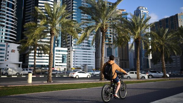 Мальчик катается на велосипеде по улице города Шарджа в ОАЭ