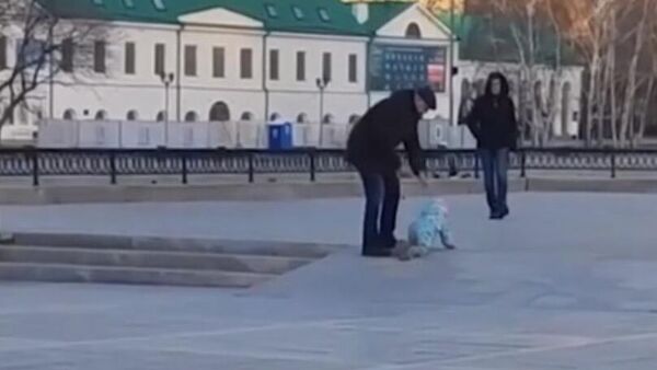 Мужчина выгуливает ребенка предположительно на поводке в центре Екатеринбурга