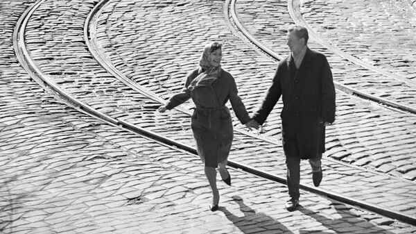 Влюбленная пара идет через трамвайные линии. Москва