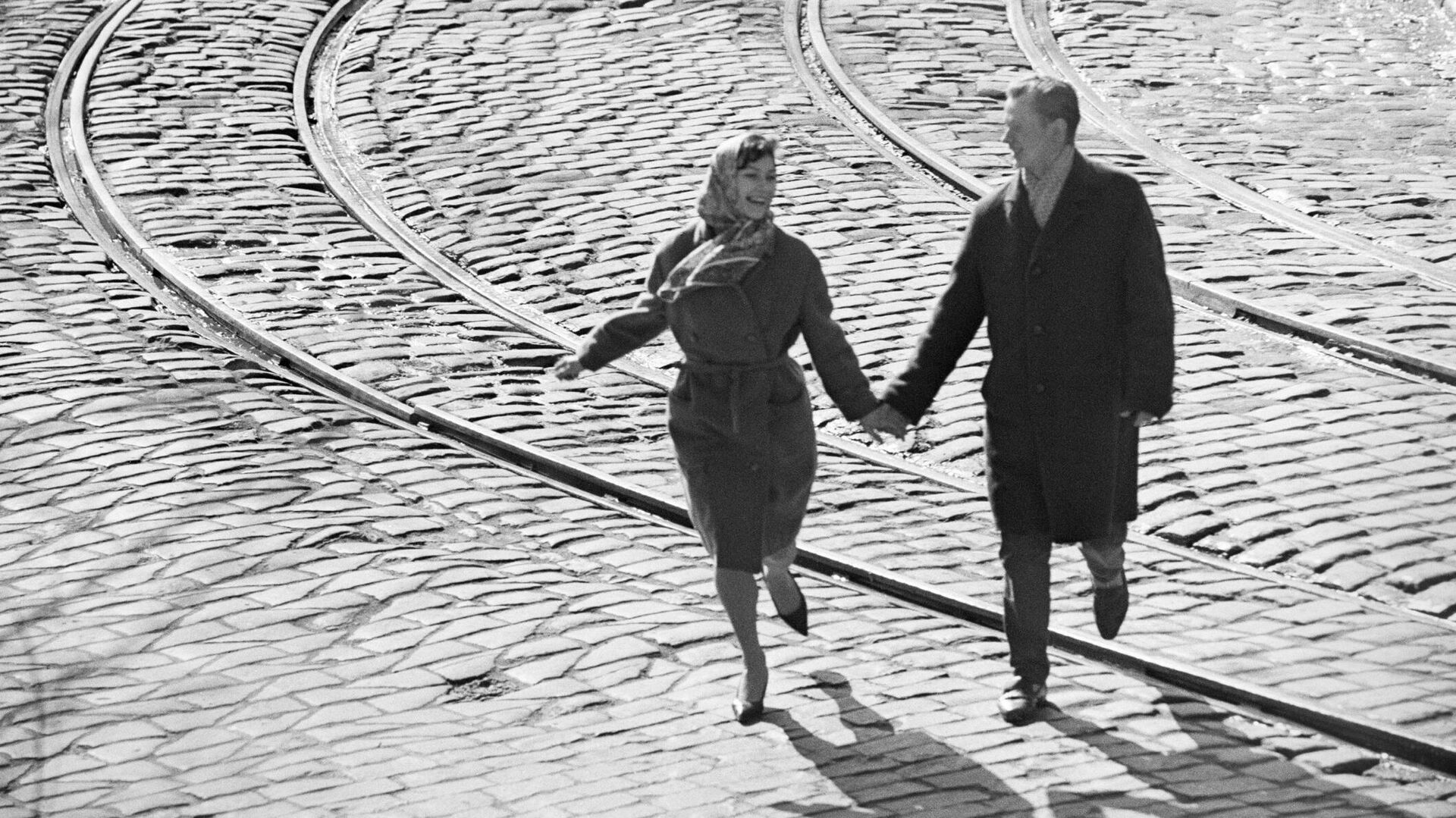 Влюбленная пара идет через трамвайные линии. Москва - РИА Новости, 1920, 15.04.2023