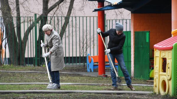 Жители города участвуют в уборке двора на улице Знаменская во время общегородского субботника в Москве.