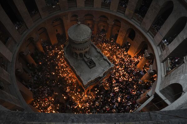 Паломники держат свечи во время церемонии схождения Благодатного огня в храме Гроба Господня