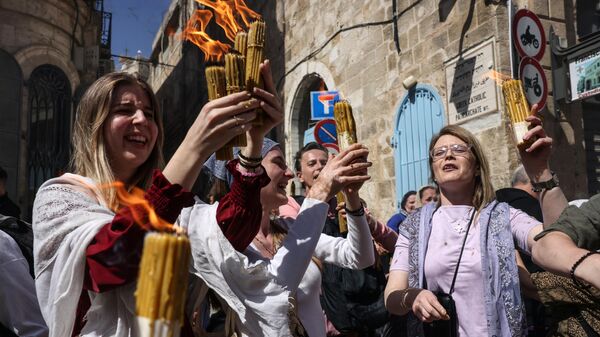 Верующие со свечами, зажженными от Благодатного огня, сошедшего в храме Гроба Господня в Иерусалиме
