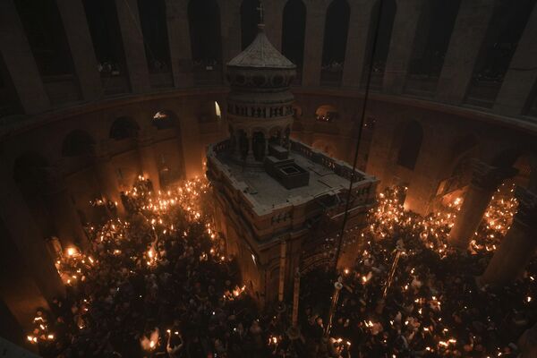 Паломники держат свечи во время церемонии схождения Благодатного огня в храме Гроба Господня