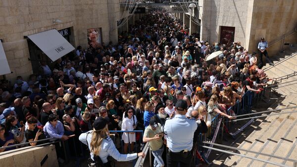 Верующие у ворот в старом городе Иерусалима, которые ведут к храму Гроба Господня, в Пасхальную субботу