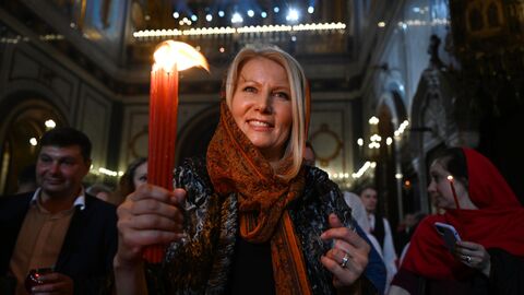 Прихожане в храме Христа Спасителя зажигают свечи от Благодатного огня после пасхального богослужения