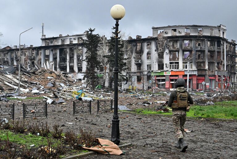 Боец ЧВК Вагнер у разрушенного здания горсовета в центре Артемовска