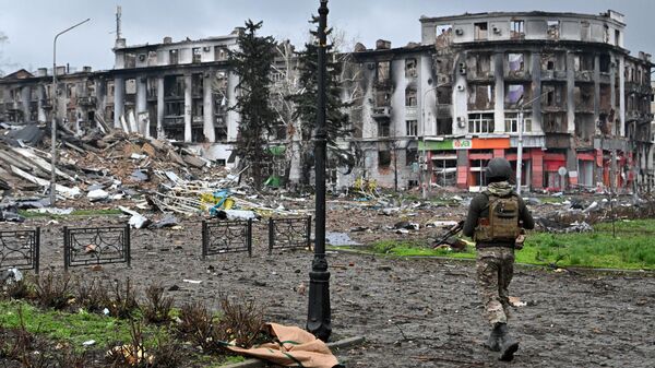 Боец ЧВК Вагнер у разрушенного здания горсовета в центре Артемовска