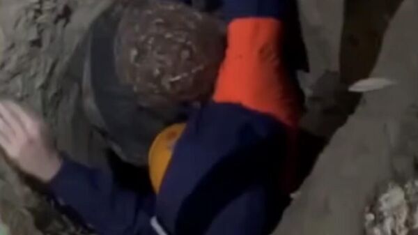 Спасатели помогают выбраться мужчине из ямы для сваи в Якутске
