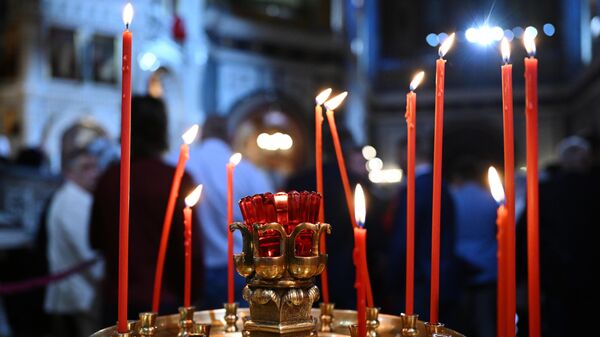 Свечи, зажженные прихожанами в храме Христа Спасителя перед началом богослужения 