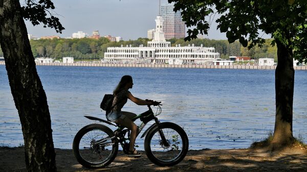 Девушка катается на велосипеде в парке около Северного речного вокзала в Москве