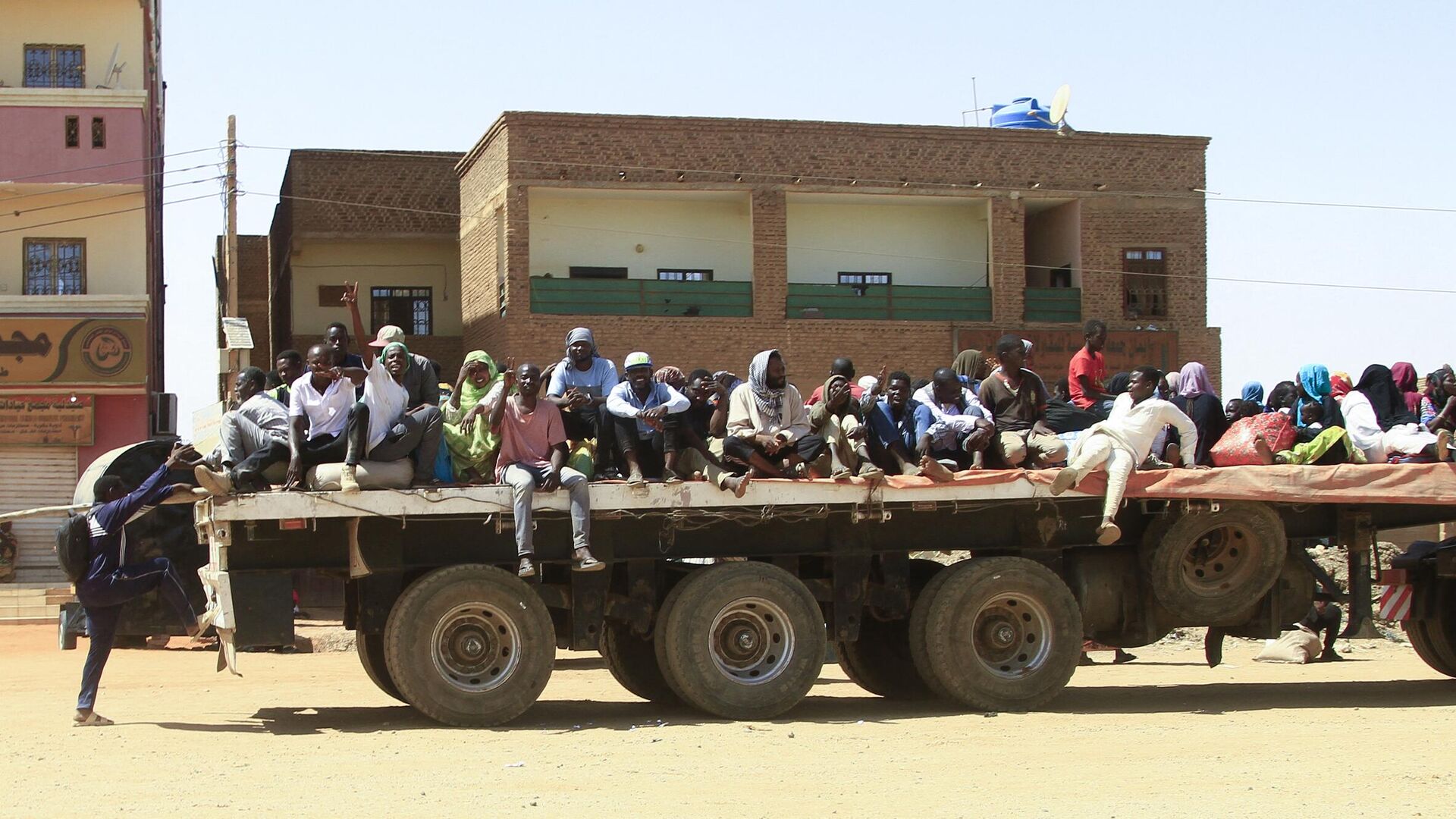 Люди спасаются от уличных боев между силами двух соперничающих суданских генералов в кузове грузовика - РИА Новости, 1920, 21.04.2023