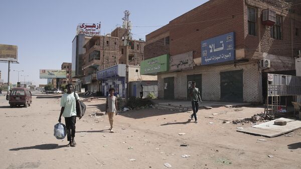 Люди проходят мимо магазинов в Хартуме, Судан