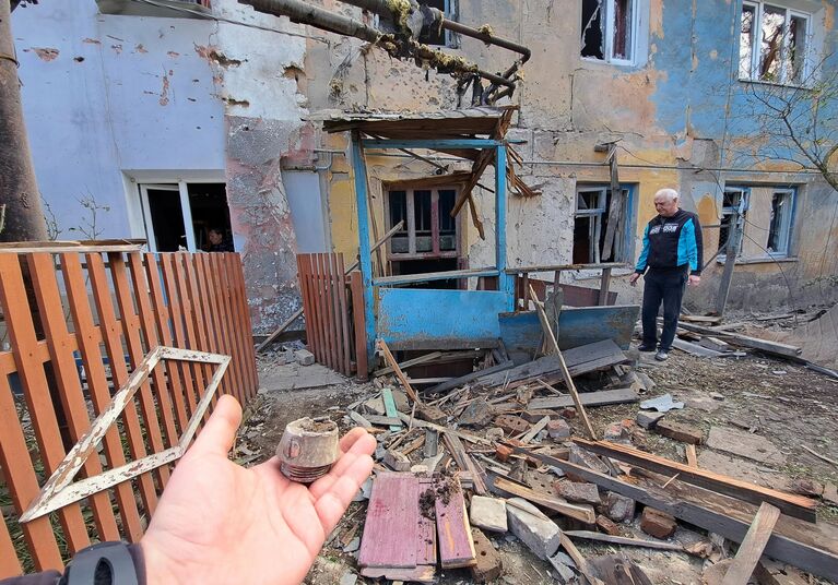 Мужчина во дворе многоквартирного жилого дома, частично разрушенного в результате обстрела ВСУ Петровского района Донецка