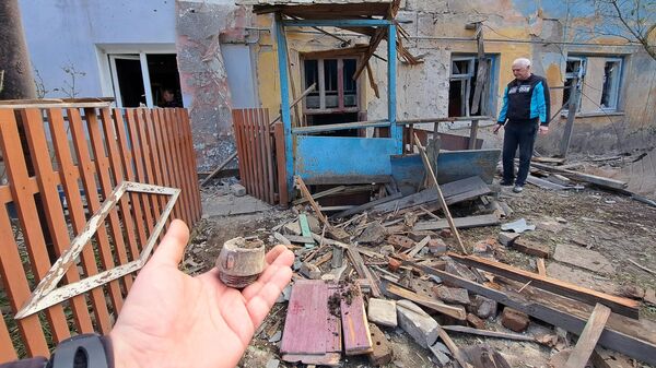 Мужчина во дворе многоквартирного жилого дома, частично разрушенного в результате обстрела ВСУ Петровского района Донецка