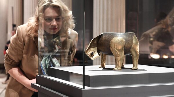 Посетительница рассматривает сосуд в виде фигуры медведя на выставке Золото сарматских вождей в Государственном музее изобразительных искусств имени А. С. Пушкина в Москве