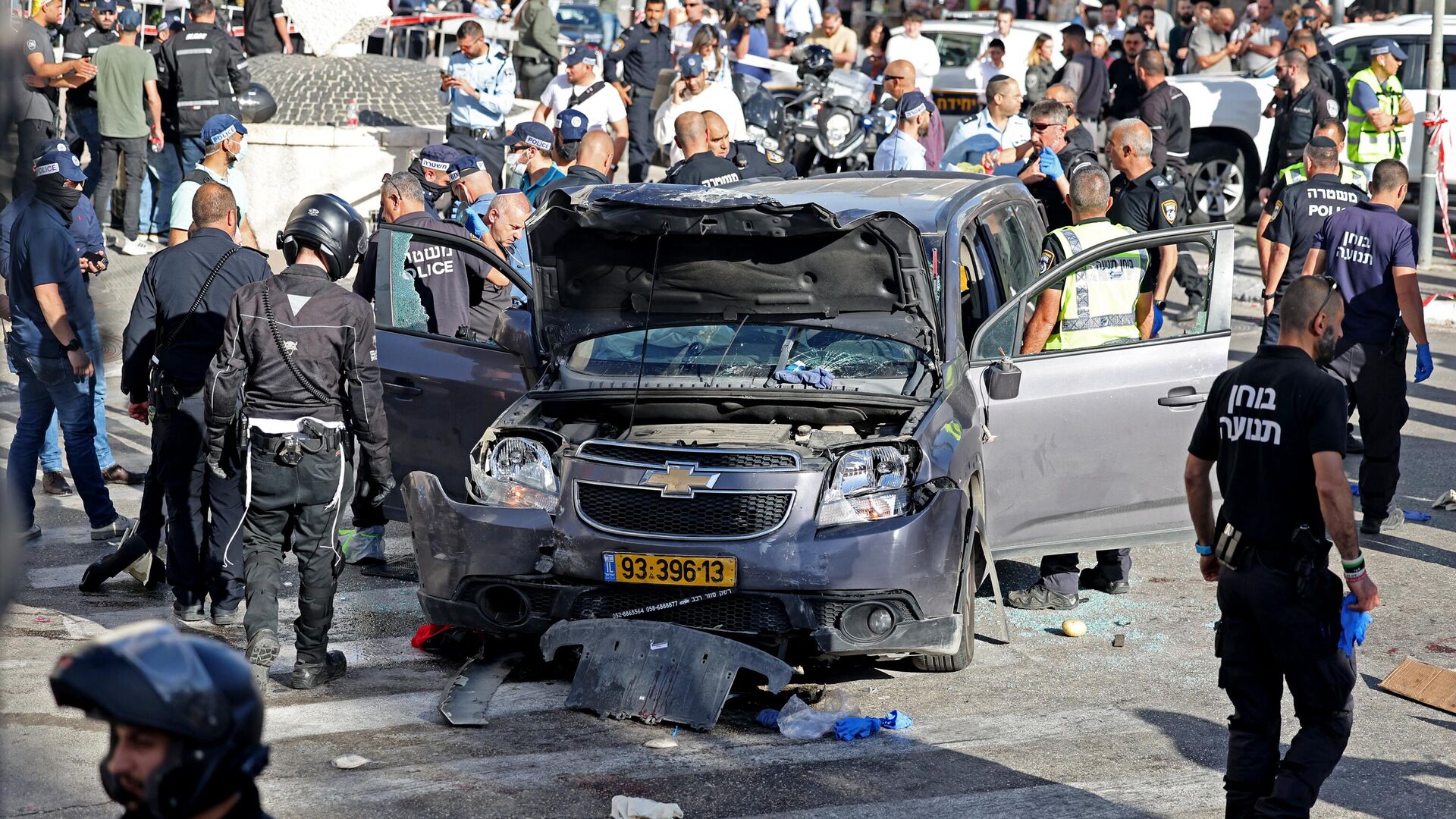 Израильская полиция и сотрудники службы экстренной помощи осматривают поврежденный автомобиль после инцидента в Иерусалиме. 24 апреля 2023 года - РИА Новости, 1920, 24.04.2023
