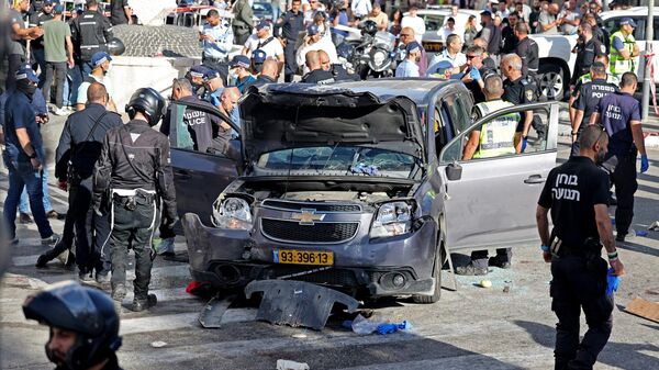 Израильская полиция и сотрудники службы экстренной помощи осматривают поврежденный автомобиль после инцидента в Иерусалиме. 24 апреля 2023 года