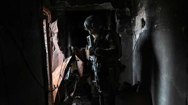 Боец ЧВК Вагнер продвигается по разрушенному дому в Артемовске
