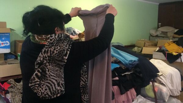 Жители города несут беженцам одежду