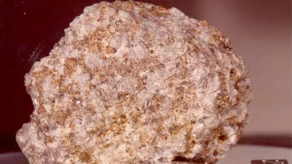 Древнейшие породы Луны. Троктолит. Образец 76535 (Аполлон-17). По мнению ученых, это самый интересный образец, найденный на Луне — древнейшая магматическая порода, состоящая из плагиоклаза (серовато-белого цвета) и оливина (зеленовато-коричневого цвета). Крупный размер зерен (2-3 мм) указывает на кристаллизацию и охлаждение на большой глубине