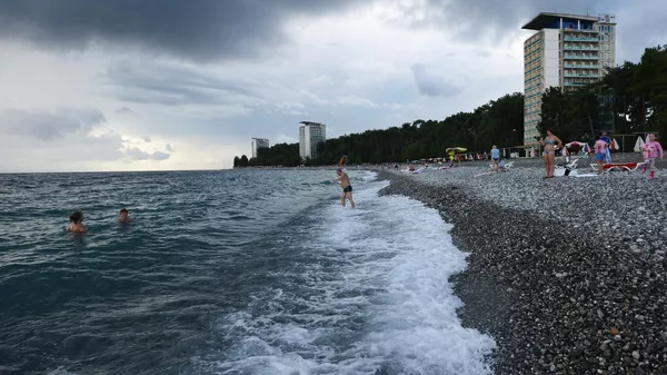 Отдыхающие на пляже города Пицунды в Абхазии