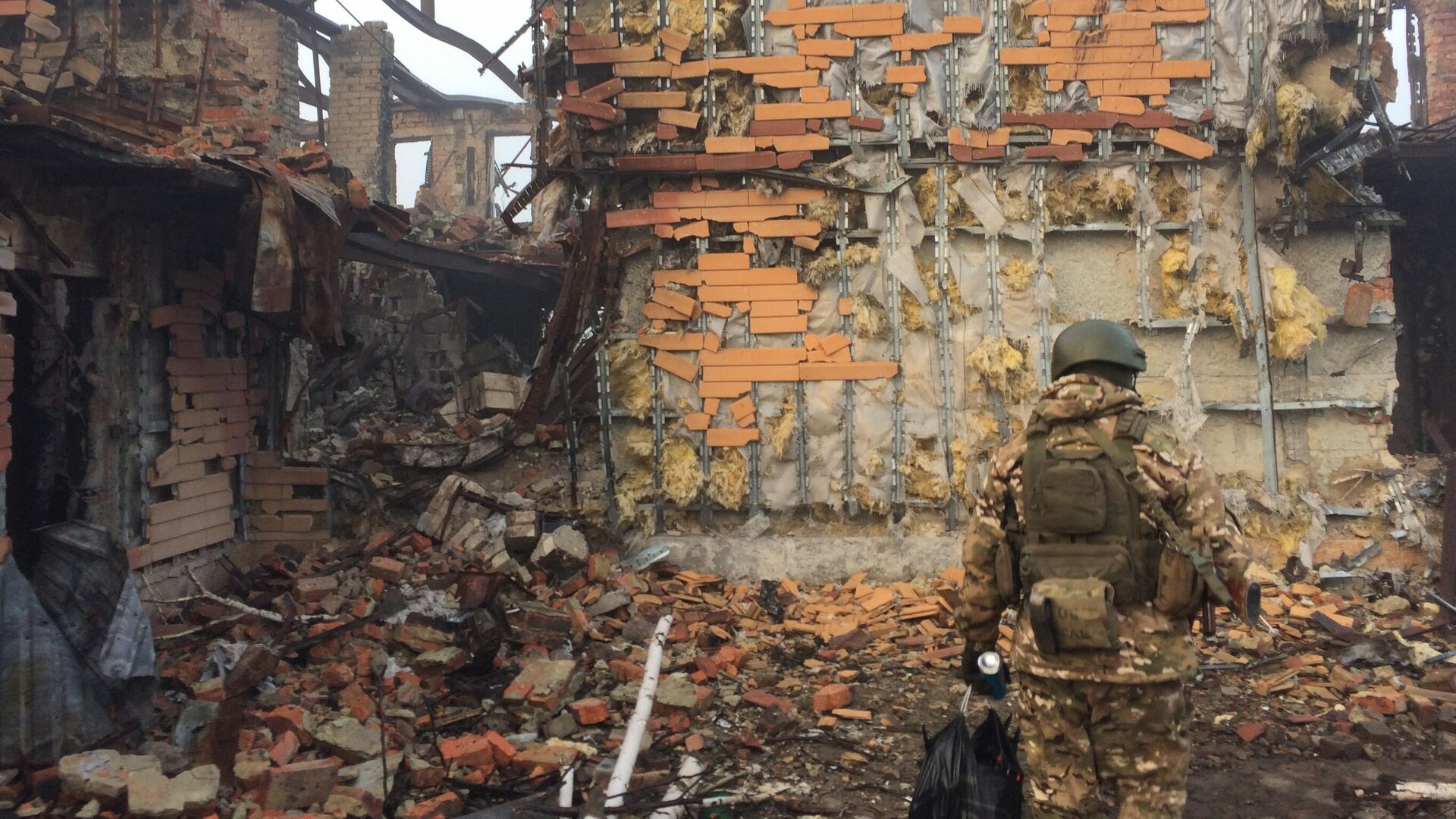 Боец на фоне разрушенного здания - РИА Новости, 1920, 07.05.2023
