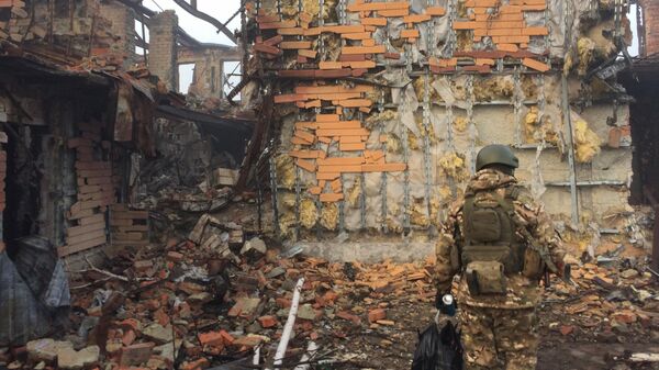 Боец на фоне разрушенного здания. Архивное фото