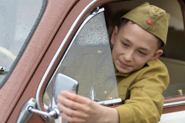 Мальчик в салоне автомобиля ГАЗ-М-20 Победа во время старта ретроралли Автопробег Победы у Музея Победы в Москве