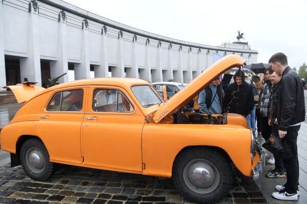 Люди у автомобиля ГАЗ-М-20 Победа во время старта ретроралли Автопробег Победы у Музея Победы в Москве