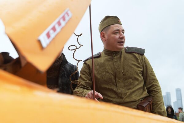 Мужчина в исторической военной форме у автомобиля ГАЗ-М-20 Победа во время старта ретроралли Автопробег Победы у Музея Победы в Москве