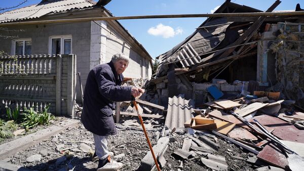 Женщина у жилого частного дома, разрушенного в результате обстрела Донецка со стороны ВСУ