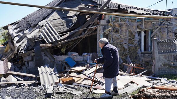 Женщина у жилого частного дома, разрушенного в результате обстрела со стороны ВСУ в Киевском районе Донецка