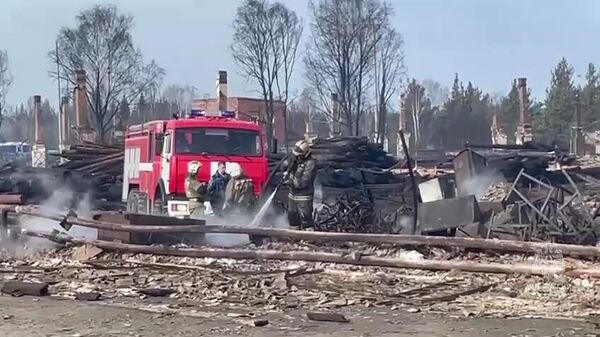 Сотрудники противопожарной службы МЧС РФ ликвидируют последствия пожара в поселке Сосьва в Свердловской области. Стоп-кадр видео