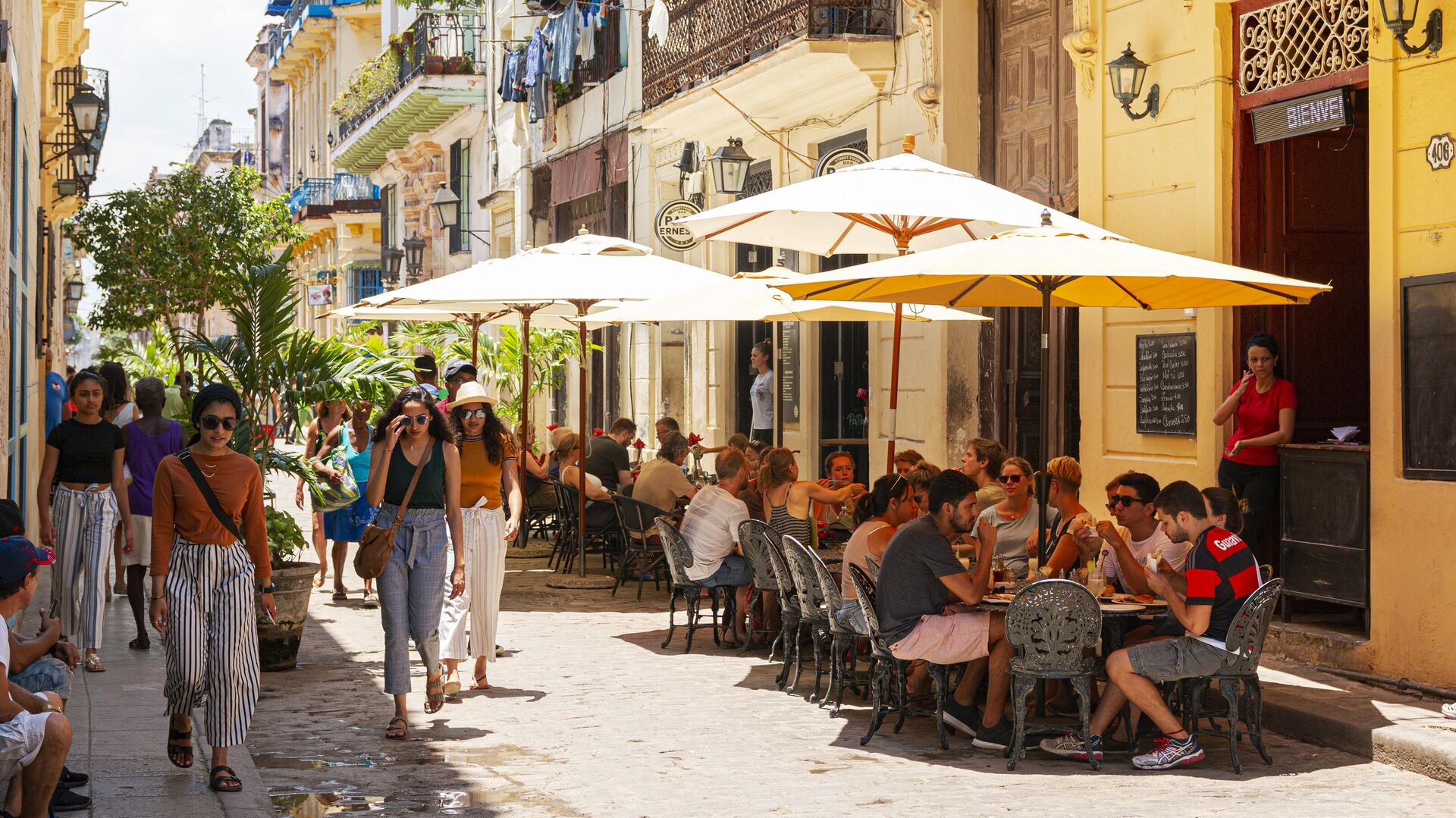 Люди проходят мимо кафе на улице Гаваны - РИА Новости, 1920, 18.12.2023