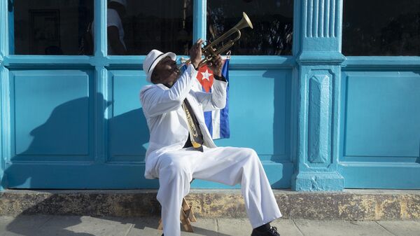 Кубинский музыкант играет на трубе на улице Старой Гаваны